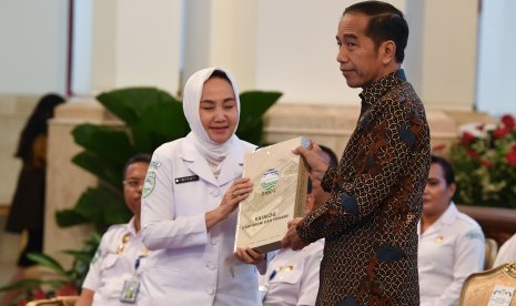 Presiden Joko Widodo (kanan) menerima katalog gempa bumi dan tsunami dari Kepala Badan Meteorologi, Klimatologi dan Geofisika (BMKG) Dwikorita Karnawati (kiri) saat membuka Rapat Koordinasi Nasional (Rakornas) BMKG tahun 2019 di Istana Negara, Jakarta, Selasa (23/7/2019). 