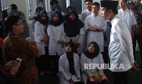 Presiden Joko Widodo (kanan) mengamati mahasiswa yang melakukan pelatihan ketika mengunjungi Universitas Aisyiyah di Yogyakarta, Kamis (6/12/2018).