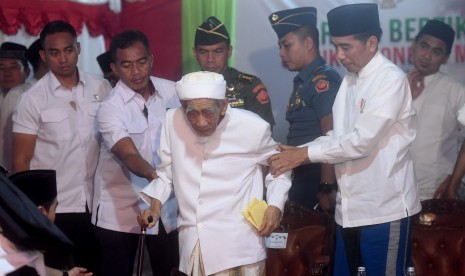 Presiden Joko Widodo (kanan) menuntun Pimpinan Pondok Pesantren Al-Anwar Sarang Maimoen Zubair (tengah) saat menghadiri acara Sarang Berzikir Untuk Indonesia Maju di Rembang, Jawa Tengah, Jumat (1/2/2019).