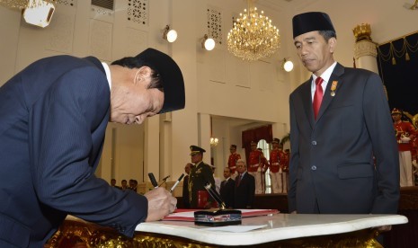 Presiden Joko Widodo (kanan) menyaksikan pendandatanganan dokumen pelantikan Kepala BIN Sutiyoso (kiri) usai mengucapkan sumpah jabatan di Istana Merdeka, Jakarta, Rabu (8/7). (Antara/Yudhi Mahatma)