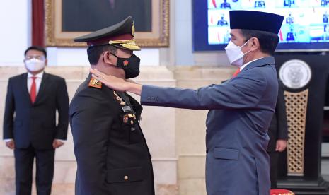 Presiden Joko Widodo (kanan) menyematkan tanda pangkat kepada Kapolri Jenderal Pol Listyo Sigid Prabowo (kiri) saat upacara pelantikan di Istana Negara, Jakarta.