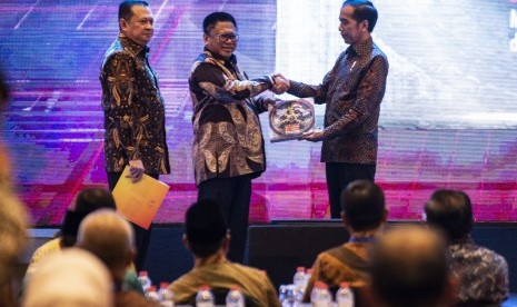 Presiden Joko Widodo (kanan) menyerahkan buku kepada Ketua DPD Oesman Sapta Odang (tengah) disaksikan Ketua DPR Bambang Soesatyo (kiri) dalam Peluncuran Geoportal Kebijakan Satu Peta dan Buku Kemajuan Infrastruktur Nasional Tahun 2018, di Jakarta, Selasa (11/12/2018). 