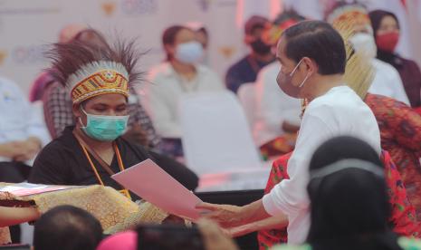 Presiden Joko Widodo (kanan) menyerahkan Nomor Induk Berusaha (NIB) kepada perwakilan pelaku usaha mikro kecil menengah (UMKM) perseorangan. PT Bank Negara Indonesia (Persero) Tbk bersinergi dengan Badan Koordinasi Penanaman Modal (BKPM) mengadakan sosialisasi dan bimbingan melalui webinar untuk mendorong UMKM mendapatkan Nomor Induk Berusaha (NIB).