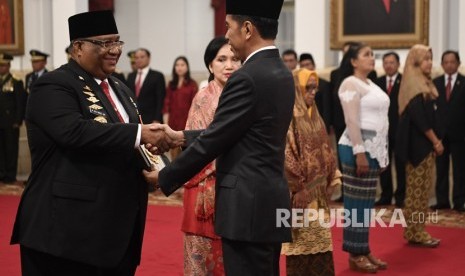 Presiden Joko Widodo (kanan) menyerahkan plakat anugerah gelar pahlawan nasional kepada ahli waris tokoh asal Sulawesi Tenggara Sultan Himayatuddin, Gubernur Sulawesi Tenggara Ali Mazi (kiri) di Istana Negara, Jakarta, Jumat (8/11/2019). 