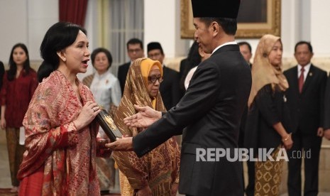 Presiden Joko Widodo (kanan) menyerahkan plakat anugerah gelar pahlawan nasional kepada ahli waris Prof Dr M Sardjito di Istana Negara, Jakarta, Jumat (8/11/2019).