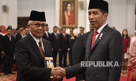 Presiden Joko Widodo (kanan) menyerahkan plakat anugerah gelar pahlawan nasional kepada ahli waris tokoh asal Sumatera Barat Ruhana Kudus di Istana Negara, Jakarta, Jumat (8/11/2019). 