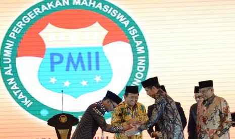 Presiden Joko Widodo (kedua kanan) berjabat tangan dengan Sekjen Ikatan Alumni Pergerakan Mahasiswa Islam Indonesia (PMII) Hanif Dhakiri (kiri) disaksikan Ketua Umum PBNU Said Aqil Siroj (kanan) dan Ketua Umum Ikatan Alumni PMII Ahmad Muqowam seusai membuka munas ke-VI Ikatan Alumni PMII di Jakarta, Jumat (20/7). 