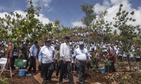 Presiden Joko Widodo (kedua kanan) bersama Mentri Lingkungan Hidup, Siti Nurbaya Bakar (ketiga kanan) berjalan meninjau lahan kritis seusai menanam pohon jati saat acara Peringatan Hari Menanam Pohon Indonesia dan Bulan Menanam Nasional Tahun 2017 di Ponjong, Gunungkidul, DI Yogyakarta, Sabtu (9/12). Dalam acara yang digagas oleh Kementrian Linkungan Hidup itu sebanyak 45.000 pohon ditanam pada areal lahan kritis dan Presiden Joko Widodo meminta seluruh pihak terkait dan warga berkomitmen untuk merawat tanaman yang ditanam. 