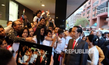 Presiden Joko Widodo (kedua kanan) dan Ibu Negara Iriana Joko Widodo (kanan) menyapa Warga Negara Indonesia (WNI) saat tiba di Hotel Four Seasons Sydney, Australia, Jumat (16/3). 