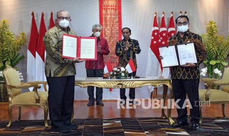 Presiden Joko Widodo (kedua kanan) dan Perdana Menteri Singapura Lee Hsien Loong (kedua kiri) menyaksikan Menteri Perhubungan Budi Karya Sumadi (kanan) dan Menteri Transportasi Singapura S Iswaran menunjukkan dokumen perjanjian penyesuaian batas wilayah informasi penerbangan Indonesia-Singapura di The Sanchaya Resort Bintan, Kabupaten Bintan, Kepulauan Riau, Selasa (25/1/2022).