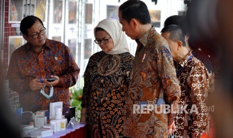 Presiden Joko Widodo (kedua kanan) didampingi Kepala Badan Pengawasan Obat dan Makanan (BPOM) Penny Kusumastuti Lukito (kedua kirin) meninjau obat-obatan ilegal dalam acara Pencanangan Aksi Nasional Pemberantasan Obat Ilegal dan Penyalahgunaan Obat di Lapangan Buperta Cibubur, Jakarta, Selasa (3/10).