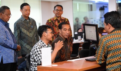 Presiden Joko Widodo (kedua kanan) didampingi Menko Perekonomian Darmin Nasution (kiri) dan Kepala BKPM Thomas Lembong (kedua kiri) berbincang dengan masyarakat ketika meninjau layanan konsultasi Online Single Submission (OSS) BKPM di PTSP BKPM Jakarta, Senin (14/1/2019).