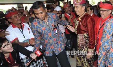 Presiden Joko Widodo (kedua kanan) didampingi Sekjen PDI Perjuangan Hasto Kristiyanto (kanan) berjalan memasuki ruangan Pembukaan Kongres V PDI Perjuangan di Sanur, Denpasar, Bali, Kamis (8/8/2019). 