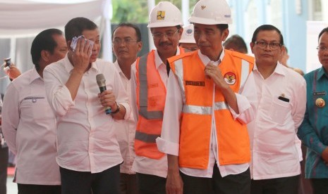 Presiden Joko Widodo (kedua kanan) didampingi Seskab PramMenhub Ignasius Jonan (kedua kiri) memberikan penjelasan kepada Presiden Jokowi saat meninjau pembangunan reaktivasi jalur kereta api Trans Sumatra.