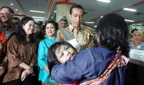 Presiden Joko Widodo (kedua kanan) memberi Kartu Indonesia Sehat (KIS), Kartu Indonesia Pintar (KIP) dan Kartu Keluarga Sejahtera (KKS).