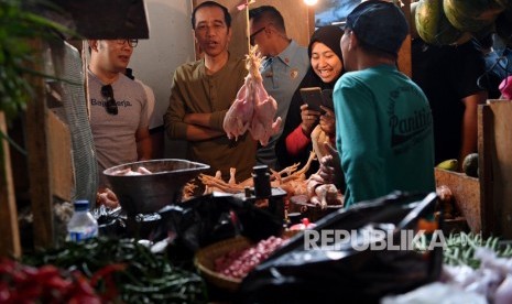 Presiden Joko Widodo (kedua kiri) berbincang dengan pedagang ketika mengunjungi Pasar Cihaurgeulis, Bandung, Jawa Barat, Ahad (11/11/2018).