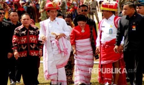 Presiden Joko Widodo (kedua kiri) bersama ibu Negara Iriana Joko Widodo (ketiga kiri) bersama Gubernur NTT Frans Lebu Raya (kiri) dan Bupati Sumba Barat Daya Markus D Tallo (kedua kanan) berjalan menuju ke lokasi digelarnya Festival Tenun Ikat saat mengunjungi Pulau Sumba di Kota Waetabula Kabupaten Sumba Barat Daya, NTT, Rabu (12/7). 