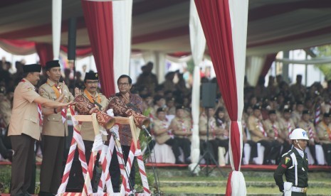 Presiden Joko Widodo (kedua kiri) bersama Menpora Imam Nahrawi (kiri), Seskab Pramono Anung (kanan), dan Ketua Kwartir Nasional Gerakan Pramuka Adhyaksa Dault (kedua kanan) memukul tifa sebagai tanda dibukanya Raimuna Nasional XI yang bertepatan dengan peringatan ulang tahun Pramuka ke-56 di, Bumi Perkemahan Cibubur, Jakarta, Senin (14/8).