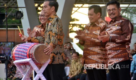 Presiden Joko Widodo (kedua kiri) di dampingi Menteri Koperasi dan UMKM, AA Gede Ngurah Puspayoga (kiri), Ketua Dewan Koperasi Indonesia, Nurdin Halid (kedua kanan), dan Gubernur Sulsel Syahrul Yasin Limpo (kanan) memukul gendang saat peringatan Hari Koperasi Nasional (Harkopnas) ke-70 di Lapangan Karebosi, Makassar, Sulawesi Selatan, Rabu (12/7).