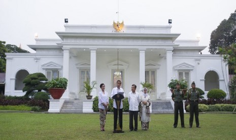  Presiden Joko Widodo (kedua kiri) didampingi Ibu Iriana Joko Widodo (kiri), Wapres Jusuf Kalla (keempat kanan), dan Ibu Mufidah Jusuf Kalla (ketiga kanan) mengumumkan susunan menteri Kabinet Kerja di Istana Merdeka, Jakarta, Ahad (26/10). 