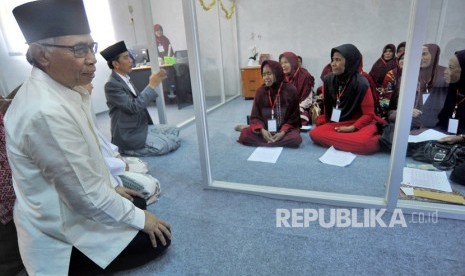 Presiden Joko Widodo (kedua kiri) didampingi Ketua Dewan Komisioner OJK (Otoritas Jasa Keuangan) Wimboh Santoso (kiri) berdialog dengan nasabah Bank Wakaf Mikro Tanara saat Peluncuran Bank Wakaf Mikro Tanara di Serang, Banten, Rabu (14/3).