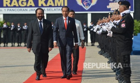 President Joko Widodo (second left) accompanied by Nasdem Party Chairman Surya Paloh (left) and Coordinating Minister for Political, Legal, and Security Affairs Wiranto (third left) inspect participants of Nasdem's State Defense Academy Batch II in Jakarta, Monday (July 16).