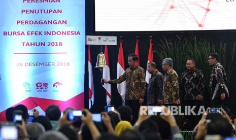 Presiden Joko Widodo (kedua kiri) didampingi Menko Perekonomian Darmin Nasution (kiri), Ketua Dewan Komisioner OJK Wimboh Santoso (kedua kanan) dan Dirut PT Bursa Efek Indonesia Inarno Djajadi melakukan seremoni penutupan Indeks Harga Saham Gabungan (IHSG) 2018 di kantor Bursa Efek Indonesia, Jakarta, Jumat (28/12/2018). 