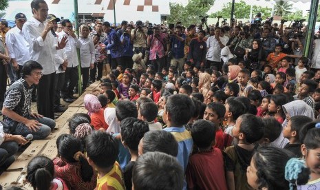 Presiden Joko Widodo (kedua kiri) didampingi Menteri Kesehatan Nila F. Moeloek (kelima kiri), Seskab Pramono Anung (keempat kiri) dan pemerhati anak Seto Mulyadi (kiri) menyapa anak-anak korban gempa di halaman Masjid Atta Darut, Pidie Jaya, Aceh, Jumat (9