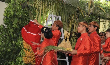 Presiden Joko Widodo (kedua kiri) disaksikan Ibu Negara Iriana Joko Widodo (kiri) dan putranya, Gibran Rakabuming Raka (ketiga kiri) dan Kaesang Pangarep (ketiga kanan) untuk membuka tuwuhan dan memasang 