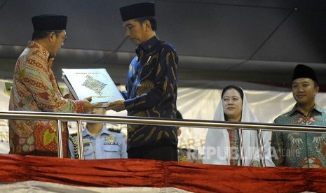 Presiden Joko Widodo (kedua kiri) disaksikan Menko PMK Puan Maharani (kedua kanan) dan Menpora Imam Nachrowi (kanan) menerima Alquran Mushaf Santri dari Menteri Agama Lukman Hakim Syaefudin (kiri) pada acara pembukaan Pospenas (Pekan Olah Raga dan Seni San