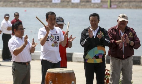 Presiden Joko Widodo (Kedua kiri) disaksikan Panglima Santri Nusantara Muhaimin Iskandar (kiri) dan Menteri Pekerjaan Umum dan Perumahan Rakyat (PUPR) Basuki Hadimuljono (tengah), Menpora Imam Nahrawi dan Gubernur Sumatera Selatan Alex Noerdin (kanan) memukul genderang tanda dimulainya Lomba Dayung Perahu Naga Piala Presiden RI di arena dayung Jakabaring Rowing and Canoeing Regatta Course, Jakabaring Sport City (JSC), Palembang, Sumatera Selatan, Sabtu (14/7). 