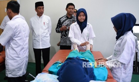 Presiden Joko Widodo (kedua kiri) mengamati mahasiswa yang melakukan pelatihan penanganan pasien saat mengunjungi Universitas Aisyiyah di Yogyakarta, Kamis (6/12/2018).