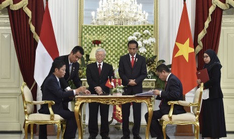 Presiden Joko Widodo (ketiga kanan) dan Sekretaris Jenderal Partai Komunis Vietnam Nguyen Phu Trong (ketiga kiri) menyaksikan penandatanganan kerjasama antaran Menteri ESDM Ignasius Jonan (kanan) dan Menteri Industri dan Perdagangan Vietnam Tran Tuan Anh (kiri) di Istana Merdeka, Jakarta, Rabu (23/8). 