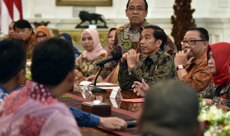 Presiden Joko Widodo (ketiga kanan) didampingi Menteri Koperasi dan UMKM Anak Agung Gede Ngurah Puspayoga (kedua kanan) dan Mensesneg Pratikno berdialog dengan pelaku UMKM di Istana Merdeka, Jakarta, Jumat (25/11).