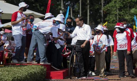 Presiden Joko Widodo (ketiga kanan) didampingi Menteri Menteri PPA I Gusti Ayu Bintang Darmawati Puspayoga (kanan) menyalami anak-anak saat menghadiri puncak peringatan Hari Anak Nasional 2022 di Kebun Raya Bogor, Jawa Barat, Sabtu (23/7/2022).