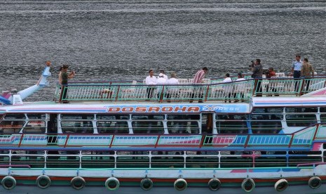 Presiden Joko Widodo (ketiga kiri) berada di atas kapal yang akan menyeberang dari Parapat ke Pulau Samosir Danau Toba, di Simalungun, Sumatera Utara, Minggu (21/8). Kedatangan Presiden ke kawasan Danau Toba dalam rangka menghadiri Karnaval Kemerdekaan Pes