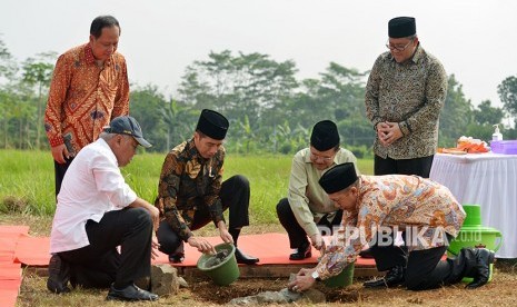 Presiden Joko Widodo (ketiga kiri) bersama Wakil Presiden Jusuf Kalla (ketiga kanan) melakukan peletakan baru pertama pembangunan Universitas Islam Internasional Indonesia (UIII) yang masuk kedalam proyek strategis nasional dengan dibantu Menteri Agama Lukman Hakim Saifuddin (kedua kanan) dan disaksikan Menristek Dikti M Nasir (kiri), Menteri PUPR Basuki Hadimuljono (kedua kiri) dan Gubernur Jawa Barat Ahmad Heryawan di Depok, Jawa Barat, Selasa (5/6).