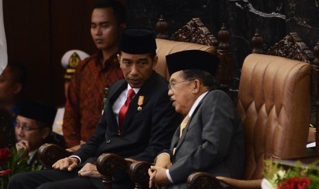 Presiden Joko Widodo (kiri) berbincang bersama Wakil Presiden Jusuf Kalla (kanan) sesaat sebelum pembacaan pidato tanggapan penyampaian nota keuangan dan RAPBN 2016 oleh di Kompleks Parlemen, Jakarta, Jumat (14/8). 