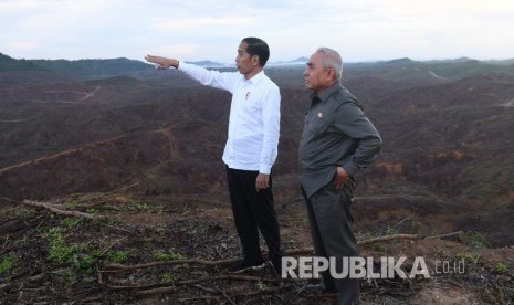 Presiden Joko Widodo (kiri) berbincang dengan Gubernur Kalimantan Timur Isran Noor (kanan) saat meninjau lokasi ibu kota baru di Sepaku, Penajam Paser Utara, Kalimantan Timur. Gubernur Kaltim Isran Noor meyakini gugatan terhadap UU IKN tidak akan berhasil.