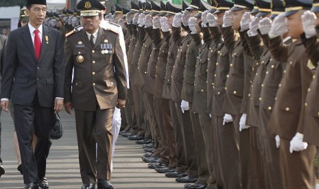 Presiden Joko Widodo (kiri) berbincang dengan Jaksa Agung M. Prasetyo (kedua kiri) ketika berjalan menuju lapangan upacara Peringatan Hari Bhakti Adhyaksa Ke-55 Tahun 2015 di Kejaksaan Agung, Jakarta, Rabu (22/7).