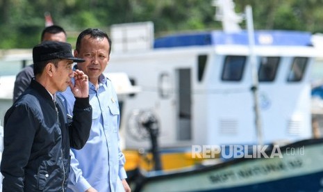 Presiden Joko Widodo (kiri) berbincang dengan Menteri Kelautan dan Perikanan Edhy Prabowo (kanan) saat melakukan kunjungan kerja di Sentra Kelautan Perikanan Terpadu (SKPT), Selat Lampa, Natuna, Kepulauan Riau, Rabu (8/1/2020). Pemerintah berencana memindahkan nelayan pesisir untuk melaut dan menangkap ikan di Natuna.