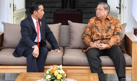 Presiden Joko Widodo (kiri) berbincang dengan Presiden Ke-6 RI Susilo Bambang Yudhoyono (kanan), di teras belakang Istana Merdeka, Jakarta, Jumat (27/10).