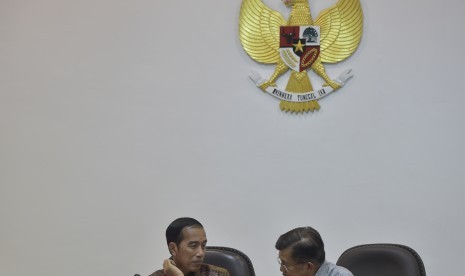 Presiden Joko Widodo (kiri) berbincang dengan Wakil Presiden Jusuf Kalla (kanan) sebelum rapat terbatas tentang harga gas untuk industri di Kantor Kepresidenan, Jakarta, Selasa (24/1).