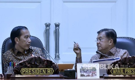 Presiden Joko Widodo (kiri) berbincang dengan Wakil Presiden Jusuf Kalla sebelum memimpin rapat terbatas tentang perkembangan implementasi program pengentasan kemiskinan di Kantor Presiden, Jakarta, Selasa (25/7). 