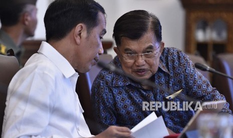 Presiden Joko Widodo (kiri) berbincang dengan Wakil Presiden Jusuf Kalla (kanan) sebelum memimpin rapat terbatas tentang pengelolaan dana haji di Istana Bogor, Jawa Barat, Kamis (26/4). 