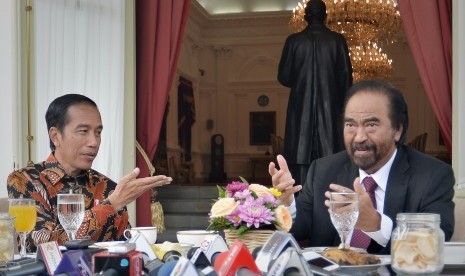 Presiden Joko Widodo (kiri) berdialog dengan Ketua Umum Partai Nasdem Surya Paloh (kanan) saat jamuan makan pagi di beranda belakang Istana Merdeka, Jakarta. 