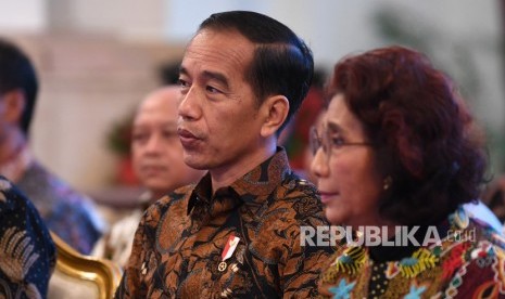 Presiden Joko Widodo (kiri) berdiskusi dengan Menteri Kelautan dan Perikanan Susi Pudjiastuti (kanan) ketika bersilahturahmi dengan pelaku usaha perikanan tangkap penerima Surat Izin Usaha Perikanan (SIUP) dan Surat Izin Penangkapan Ikan (SIPI) di Istana Negara, Jakarta, Rabu (30/1/2019).