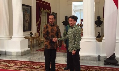 Presiden Joko Widodo (kiri) berjabat tangan dengan Egy Maulana Vikri di Istana Negara, Jumat (23/3).