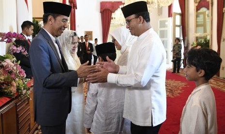 Presiden Joko Widodo (kiri) berjabat tangan dengan Gubernur DKI Jakarta Anies Baswedan (kedua kanan) saat halalbihalal di Istana Negara, Jakarta, Rabu (5/6/19).