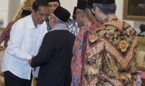 Presiden Joko Widodo (kiri) berjabat tangan dengan Ketua Umum Majelis Ulama Indonesia (MUI) KH. Ma'ruf Amin (kedua kiri) dan sejumlah undangan lainnya sebelum melakukan pertemuan di Istana Merdeka, Jakarta, Selasa (1/11). 